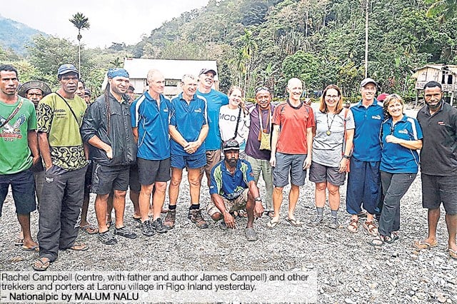 A newspaper clipping showing a large group of trekkers and porters posing together in a rocky clearing at Laronu village. The caption identifies Rachel Campbell, her father, and author James Campbell.